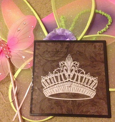 A card with a crown and fairy wings on it.